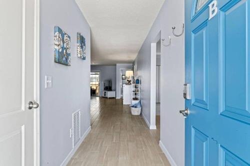 a hallway with blue doors and a hallway with a kitchen at Charming and delightful getaway! Walk to Beach in Saint Augustine