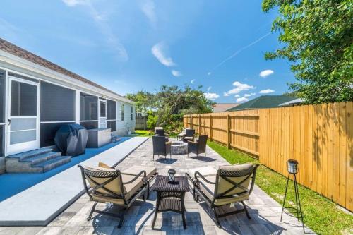 a patio with chairs and a table and a fence at Charming and delightful getaway! Walk to Beach in Saint Augustine