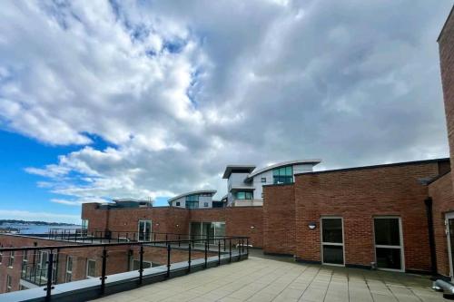a brick building with a cloudy sky in the background at Entire Prestige Apartment in Poole Quay - Free Parking, Fast WiFi, Smart TV & Netflix in Poole