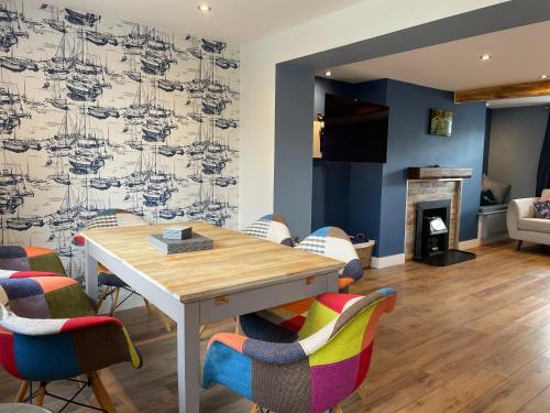 a dining room with a table and chairs and a fireplace at The Ship Inn's Mill Cottage - Weavers Way in Gatehouse of Fleet