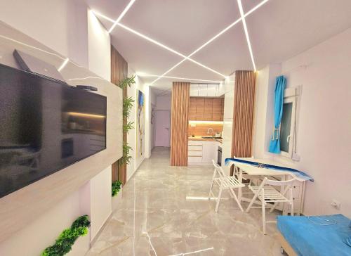 a living room with a television and a table and chairs at SUN SEA No 7 first line in Perea