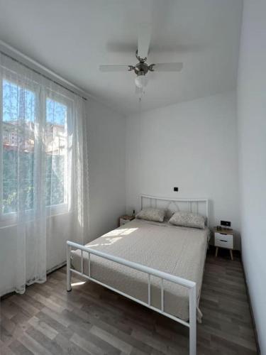 Un dormitorio blanco con una cama y una ventana. en Bougainvillea Apartments 2, en Nauplia