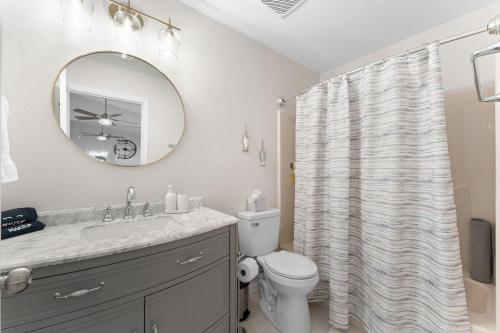 a bathroom with a sink and a toilet and a mirror at Oasis on Table Rock Lake in Kimberling City