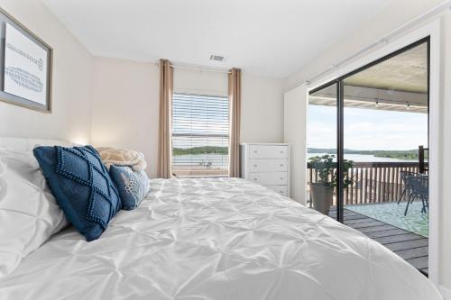 a bedroom with a large white bed and a balcony at Oasis on Table Rock Lake in Kimberling City