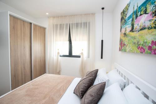 a bedroom with a bed and a painting on the wall at Apartments NIKOS FAMILY in Ulcinj