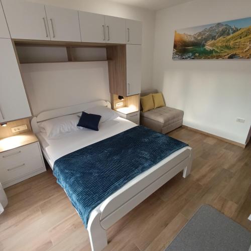 a bedroom with a large bed with a blue blanket at Apartments NIKOS FAMILY in Ulcinj
