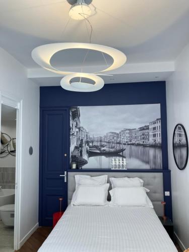 - une chambre avec un lit bleu et blanc et un lustre dans l'établissement Chambre dans Hôtel Particulier 18e siècle Hyper Centre La Rochelle, à La Rochelle