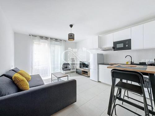 un salon avec un canapé et une cuisine dans l'établissement Grand studio 5 min des plages, à Antibes