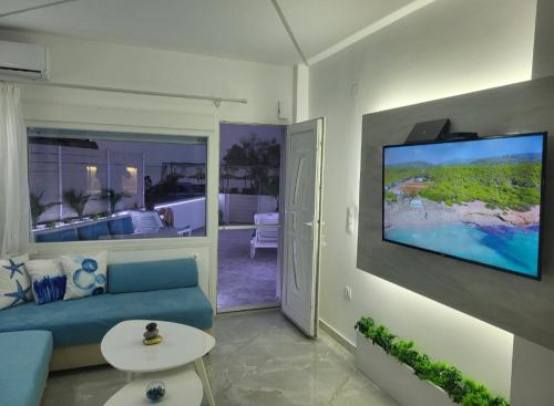 a living room with a blue couch and a flat screen tv at SUN SEA No 7 first line in Perea