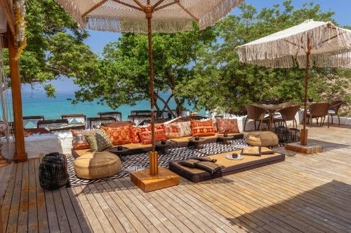 a deck with couches and umbrellas on the beach at Bora Bora Beach Club & Hotel in Isla Grande