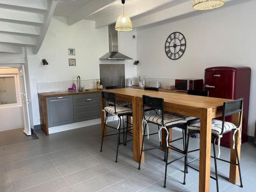 une cuisine avec une table et des chaises en bois dans l'établissement Ker Bihanic classée 3 étoiles, à Lézardrieux