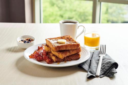 a plate of breakfast food with toast and a cup of coffee at Holiday Inn Phoenix/Chandler by IHG in Chandler