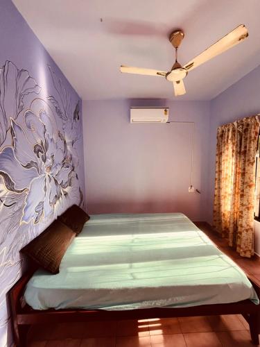 a bedroom with a bed with a blue wall at Santa Maria Hostel Kovalam in Kovalam