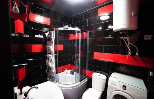 a bathroom with a red and black tiled wall at jako in Batumi