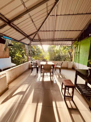a patio with a table and chairs on a roof at Santa Maria Hostel Kovalam in Kovalam