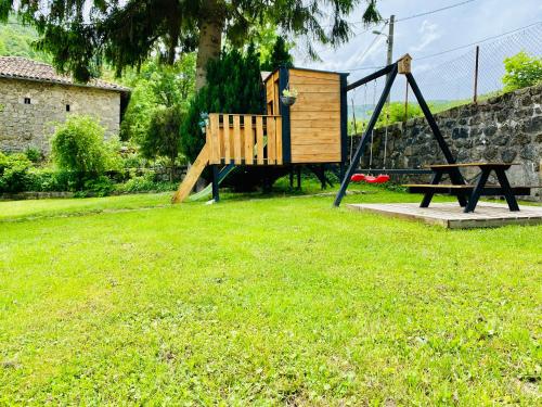 a playground with a wooden swing and a table at Ardeche2coeur in Marcols-les-Eaux
