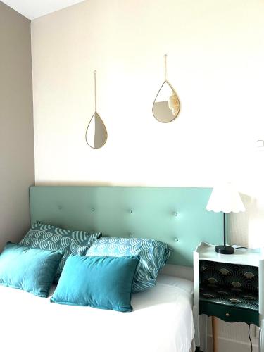 une chambre avec un lit avec des oreillers bleus dans l'établissement Appartement cosy, à Cherbourg en Cotentin