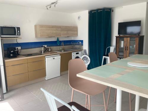 une cuisine et une salle à manger avec une table et des chaises dans l'établissement Rooftop terrasse vue phare et mer, à Berck-sur-Mer
