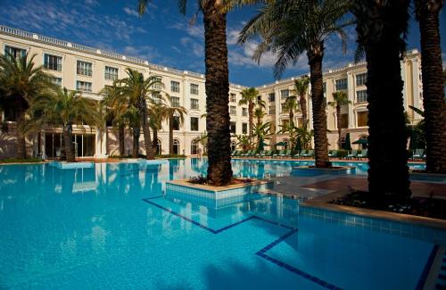 a large pool with palm trees in front of a building at IC Hotels Airport in Antalya