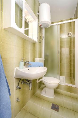 a bathroom with a white sink and a toilet at Apartment and Rooms Artina in Vodice