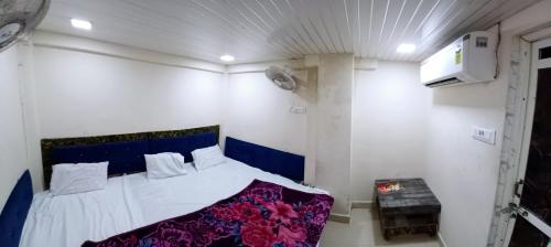 a bedroom with a bed with a blue head board at BLUE TOWER in Ujjain