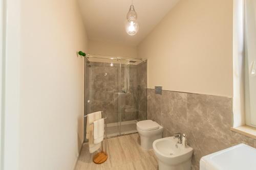 a bathroom with a shower and a toilet and a sink at Villa ELENA in Mirabella Eclano