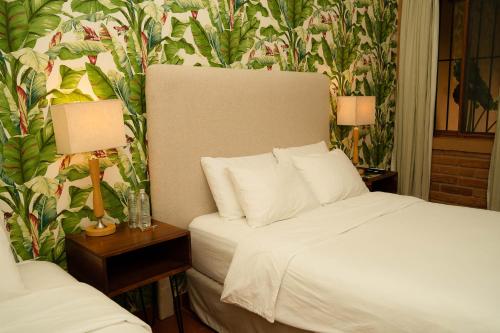 a bedroom with a bed and two tables with lamps at Caracoral Hotel Boutique in Valle de Anton