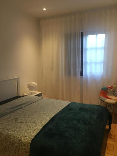 a bedroom with a bed and a window at Bela Vita, Porto Covo in Porto Covo
