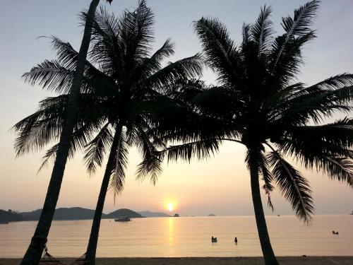 two palm trees on the beach at sunset at Happy Days Resort in Ko Mak