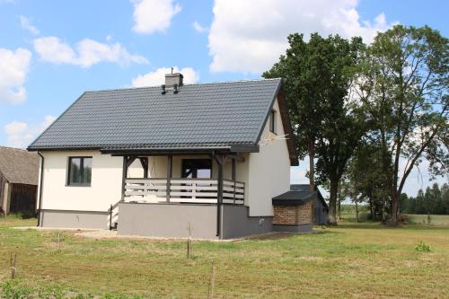 a small white house with a gambrel roof at Ostoja Tatary Agroturystyka in Tykocin