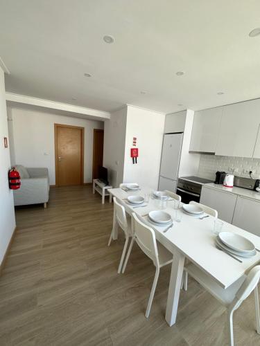 a white table with white chairs in a kitchen at Carcavelos Beach Shared Serviced Apartment 12 in Oeiras