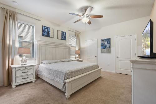 um quarto com uma cama e uma ventoinha de tecto em Windsor At Westside 8BR Home 8888 em Kissimmee