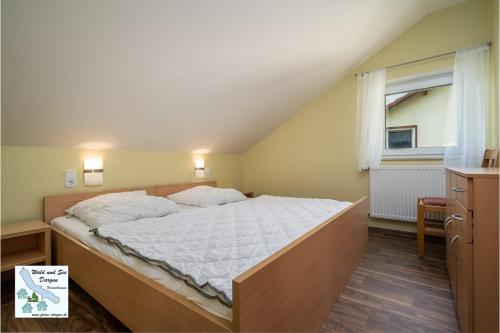 a large bed in a room with a window at Wald und See Dargun 31A in Dargun