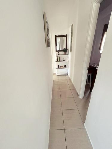 a hallway with white walls and a tile floor at PEDRO NAVARINO ΙΙΙ Laganas in Laganas