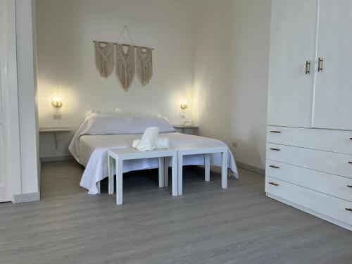 Un dormitorio blanco con una cama y una mesa. en Miky's Bay, en Forza dʼAgro