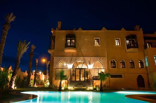 a building with a swimming pool at night at Le Temple Des Arts in Ouarzazate