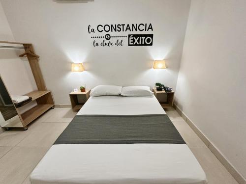 a bedroom with two beds and a sign on the wall at Hotel Boutique Gao in Cúcuta