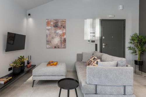 a living room with a couch and a chair at De Bosset Suites Kefalonia in Argostoli