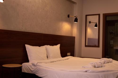 a bed with white sheets and towels on it at Clepsydra Residence in Plovdiv