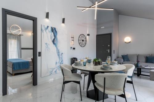 a dining room and living room with a table and chairs at De Bosset Suites Kefalonia in Argostoli