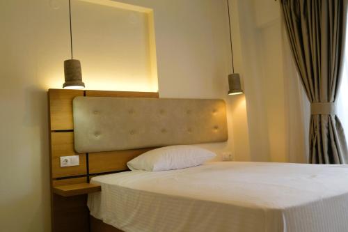 a bedroom with a bed with two lights above it at BluMango Resort in Ierissos
