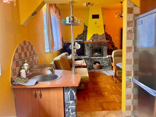 a kitchen with a sink and a fireplace at Turbacz pokoje gościnne in Ochotnica Górna