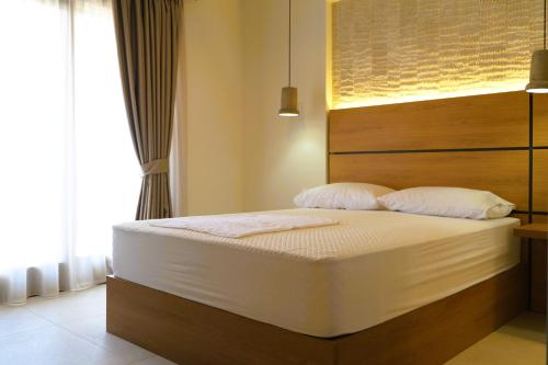 a bed with white sheets and pillows in a room at BluMango Resort in Ierissos