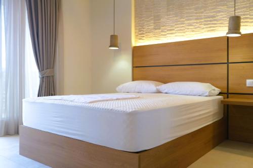 a bedroom with a large bed with white sheets at BluMango Resort in Ierissos