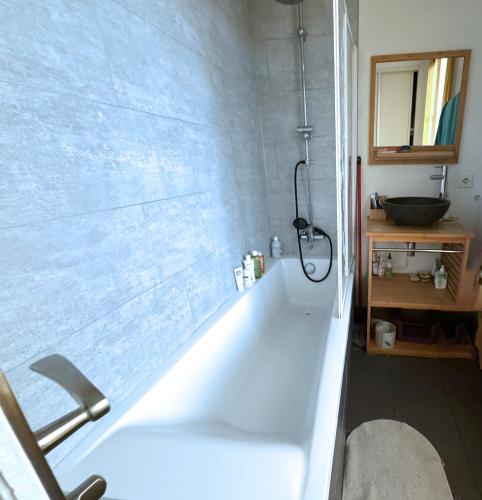 une baignoire blanche dans une salle de bain avec un lavabo dans l'établissement Symphonie Urbaine, à Pantin