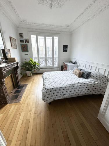 une chambre avec un lit et une cheminée dans l'établissement Symphonie Urbaine, à Pantin