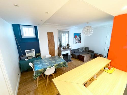 un salon avec une table et un canapé dans l'établissement Symphonie Urbaine, à Pantin