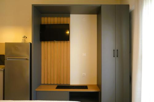 a small kitchen with a refrigerator and a table at BluMango Resort in Ierissos