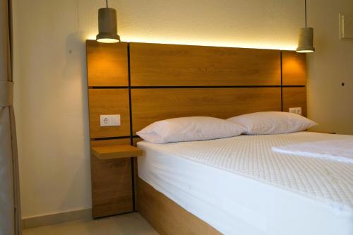 a bedroom with a large bed with a wooden headboard at BluMango Resort in Ierissos