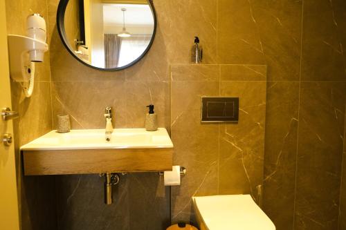 a bathroom with a sink and a mirror and a toilet at BluMango Resort in Ierissos